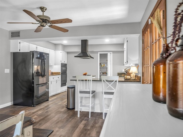 kitchen featuring dark wood-style floors, visible vents, island range hood, a peninsula, and black appliances