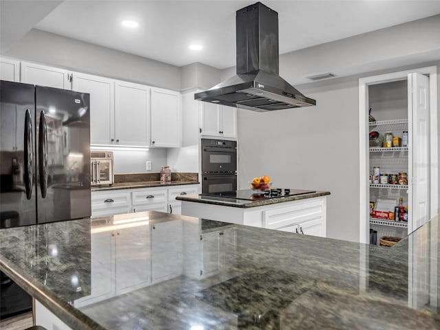 kitchen with white cabinets, a center island, dark stone counters, black appliances, and island exhaust hood