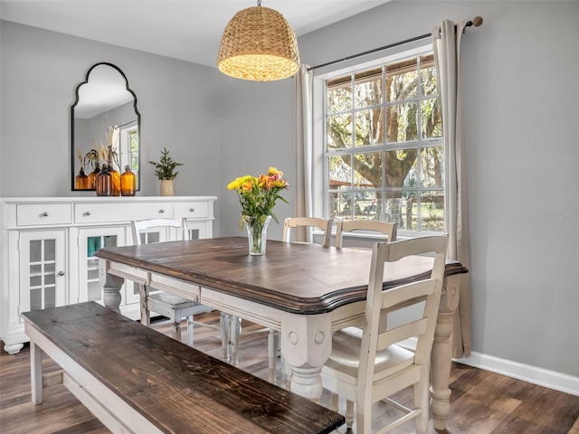 dining space featuring plenty of natural light, dark wood finished floors, and baseboards