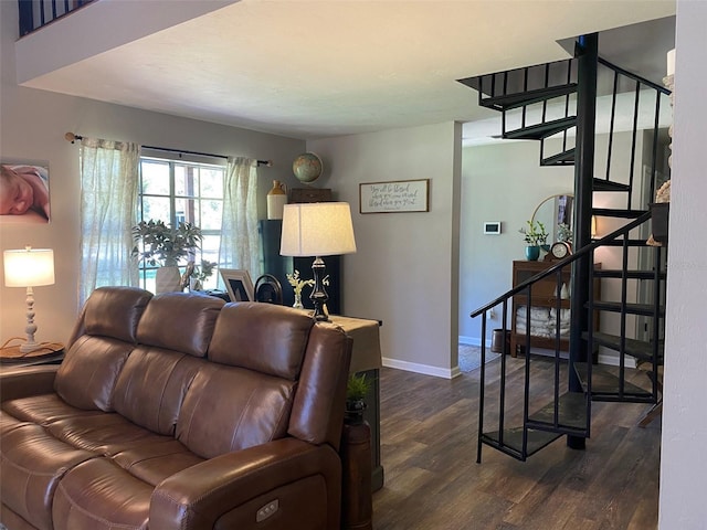 living room with dark wood-style floors, baseboards, and stairs