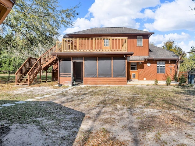 back of house featuring a shingled roof, stairway, and a sunroom