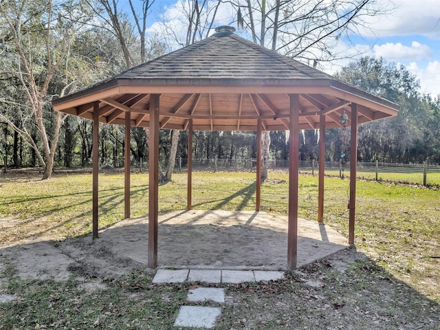 view of community featuring a gazebo, a yard, fence, and a detached carport