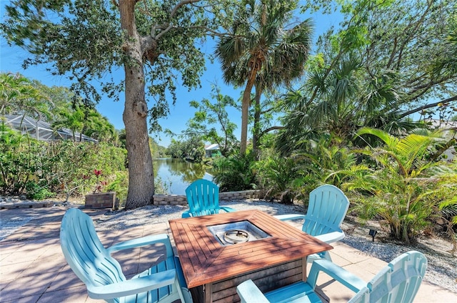 view of patio / terrace with a fire pit and a water view