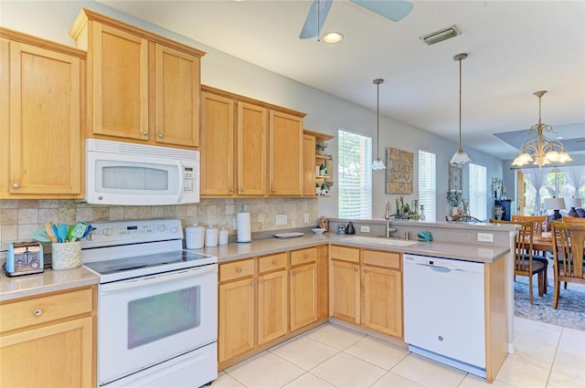 kitchen featuring a peninsula, white appliances, a sink, visible vents, and light countertops