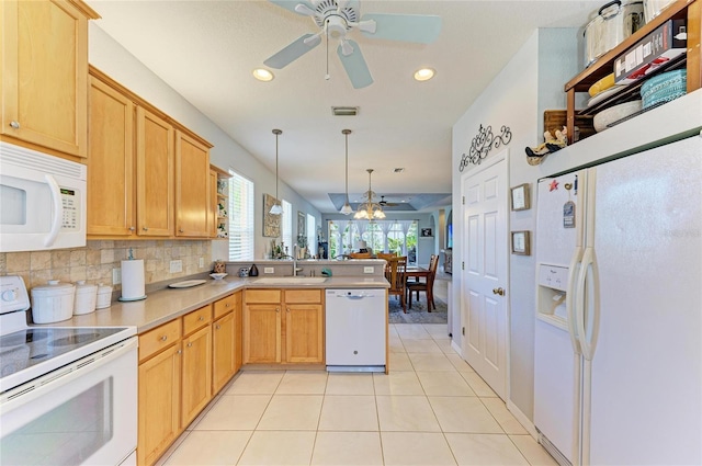 kitchen featuring open floor plan, light tile patterned flooring, a sink, white appliances, and a peninsula