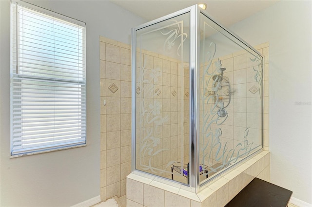 bathroom with a shower stall and baseboards