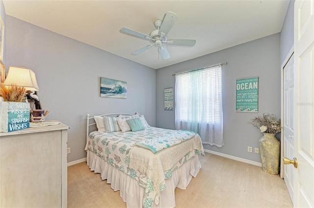 bedroom featuring a ceiling fan, light colored carpet, and baseboards