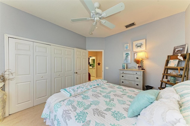 bedroom featuring light colored carpet, a closet, visible vents, and ceiling fan