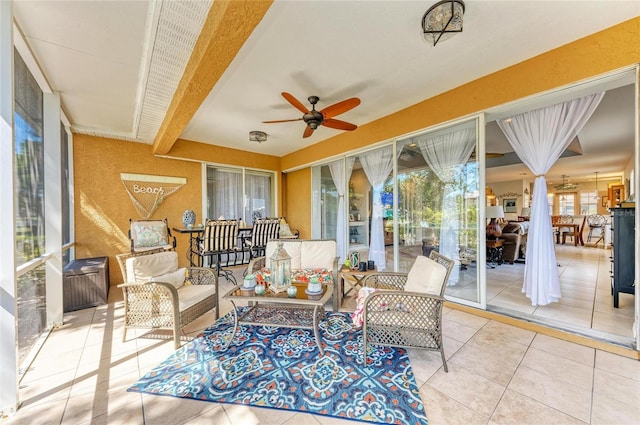 sunroom with ceiling fan and beamed ceiling