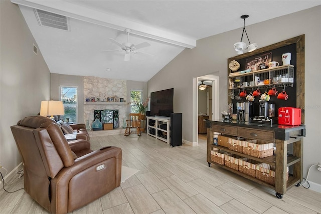 living room featuring a stone fireplace, lofted ceiling with beams, a ceiling fan, and visible vents