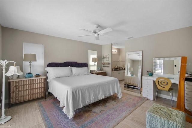 bedroom featuring visible vents, ensuite bathroom, a ceiling fan, and wood finished floors