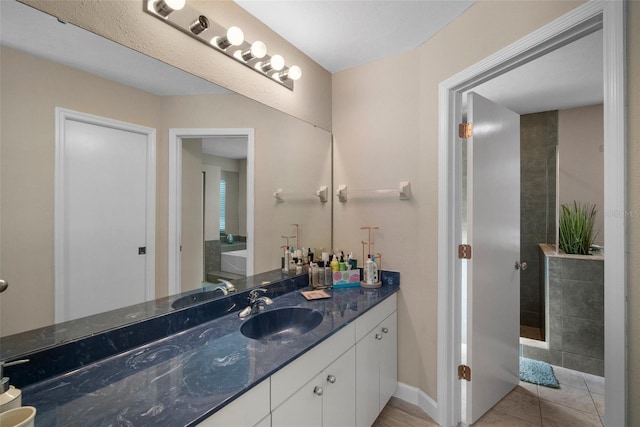 full bathroom featuring tile patterned floors, baseboards, vanity, and a walk in shower