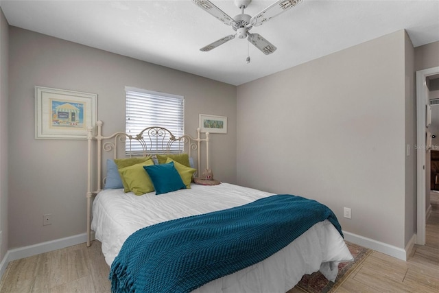 bedroom featuring baseboards, wood finished floors, and a ceiling fan