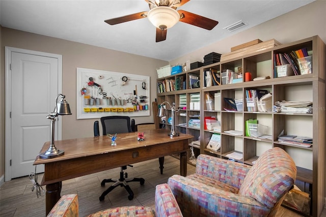 home office featuring wood finished floors, visible vents, and ceiling fan