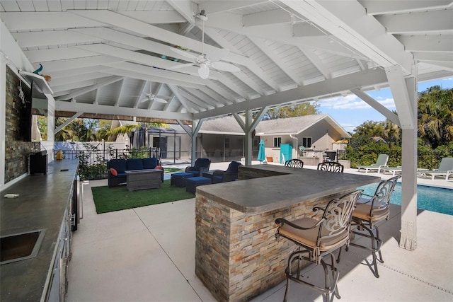 view of patio with a fenced in pool, an outdoor bar, a gazebo, an outdoor hangout area, and a ceiling fan