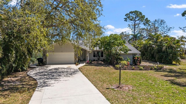 view of front facade featuring driveway, a front lawn, and an attached garage