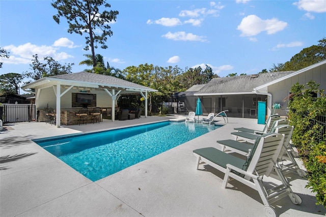 view of swimming pool featuring a patio, fence, a fenced in pool, a sunroom, and outdoor dry bar