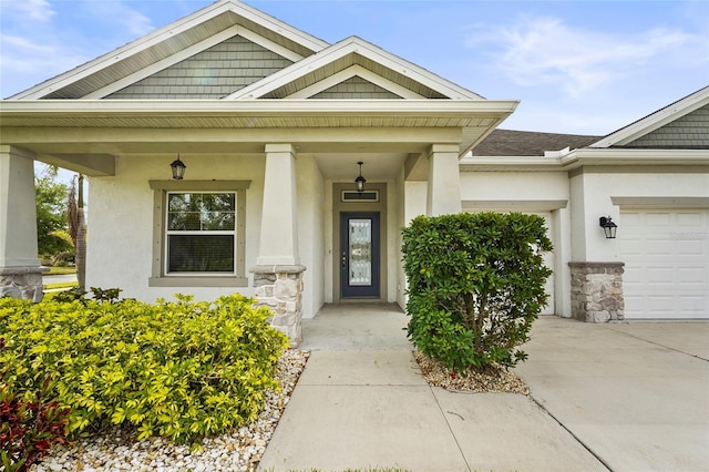 doorway to property featuring stucco siding, a garage, and concrete driveway
