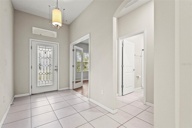 entryway with baseboards, visible vents, and light tile patterned floors