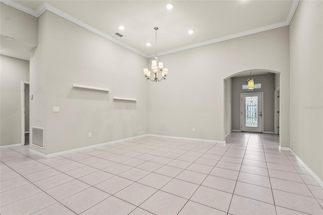 spare room with arched walkways, crown molding, and visible vents