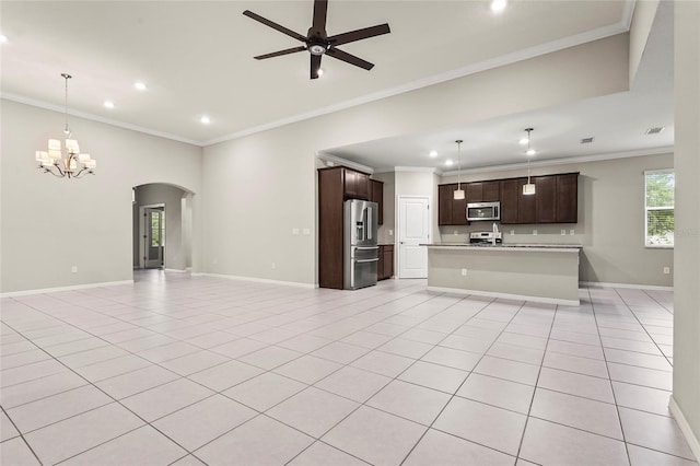 unfurnished living room with light tile patterned floors, arched walkways, ceiling fan with notable chandelier, and baseboards