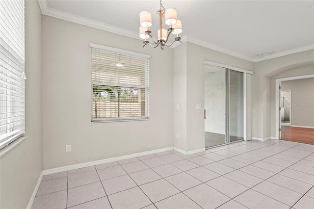 spare room featuring baseboards, light tile patterned floors, a notable chandelier, and crown molding