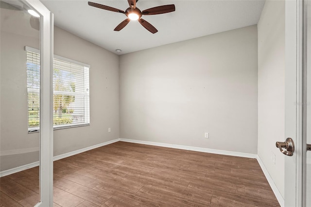 unfurnished room with baseboards, wood finished floors, and a ceiling fan