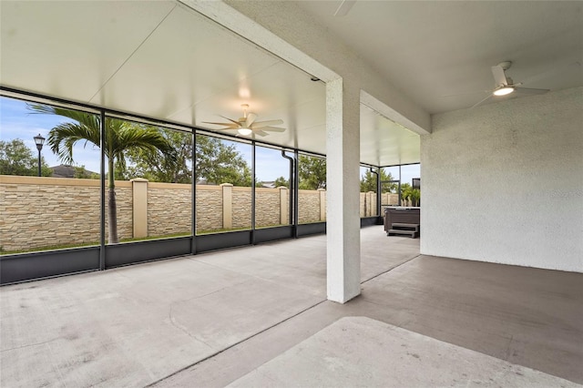 unfurnished sunroom with ceiling fan