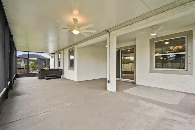 unfurnished sunroom featuring a jacuzzi and a ceiling fan