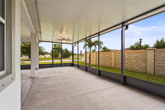 unfurnished sunroom featuring ceiling fan