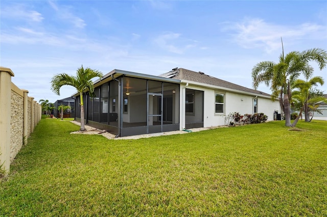 rear view of house with a sunroom, fence private yard, stucco siding, and a yard