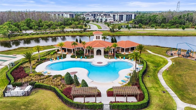 pool with a yard, a water view, fence, and a patio area