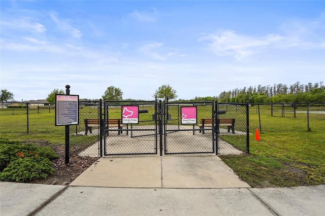 view of gate featuring fence and a yard