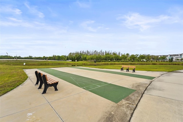 view of community with shuffleboard and a lawn