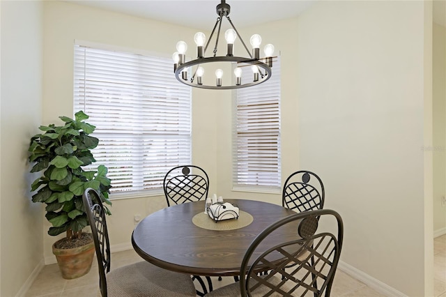 dining area with an inviting chandelier, light tile patterned flooring, and baseboards