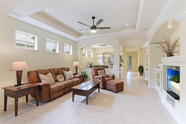 living room featuring visible vents, a tray ceiling, recessed lighting, ceiling fan with notable chandelier, and arched walkways