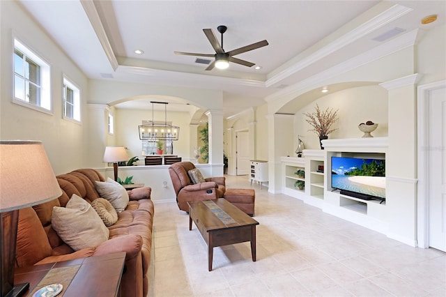 living room with a tray ceiling, arched walkways, visible vents, and ornate columns