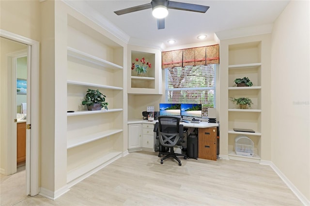 home office with built in features, baseboards, light wood finished floors, ceiling fan, and ornamental molding