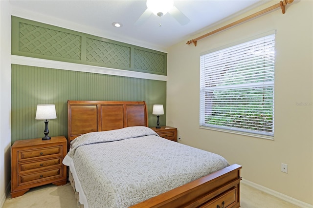 bedroom with light carpet, ceiling fan, and baseboards