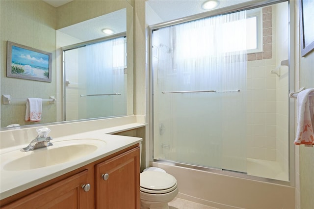 bathroom with vanity, toilet, and bath / shower combo with glass door