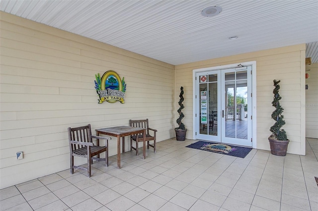 view of exterior entry with a patio area and french doors