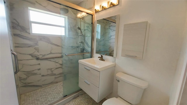 bathroom with toilet, a marble finish shower, and vanity