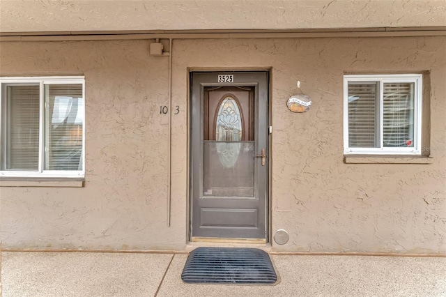 property entrance featuring stucco siding