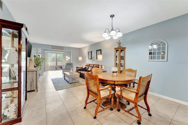 dining area featuring light tile patterned floors, baseboards, a chandelier, and a textured ceiling