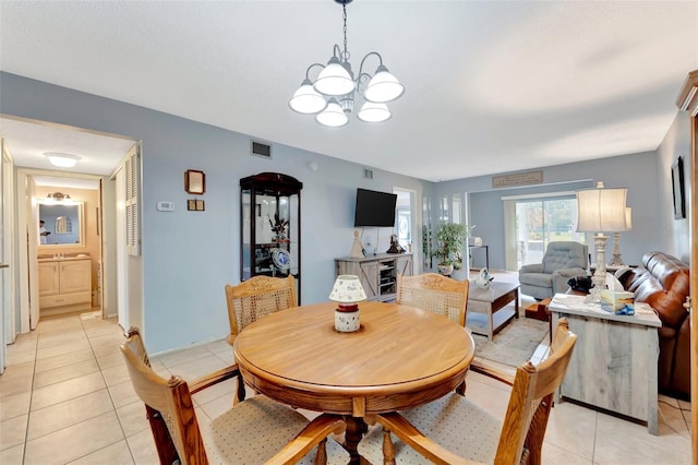 dining space with light tile patterned floors, visible vents, and a notable chandelier