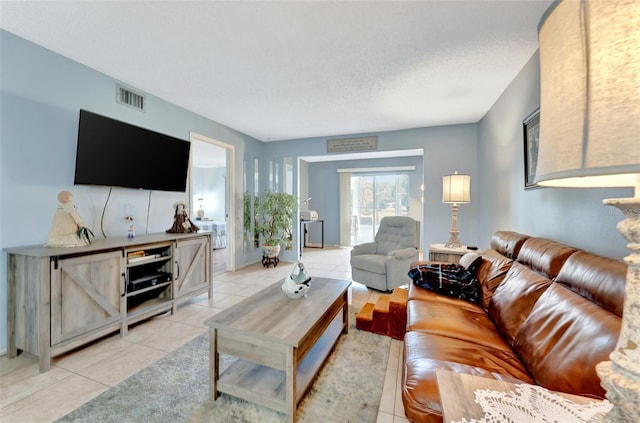 living area with visible vents, a textured ceiling, and light tile patterned flooring