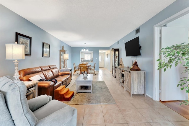 living area with light tile patterned floors, visible vents, and a textured ceiling