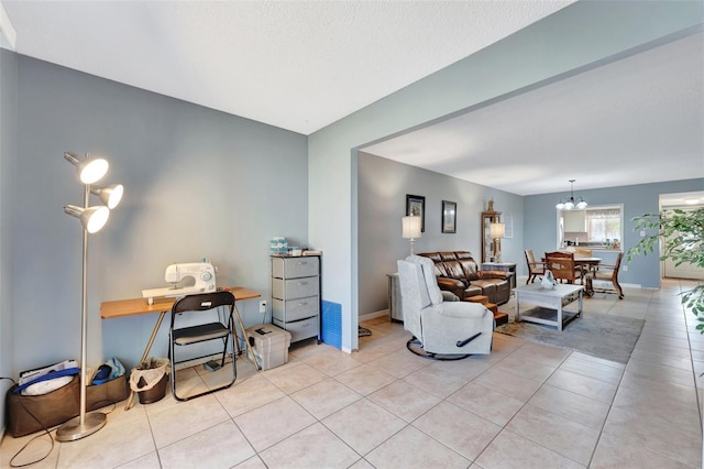 living area featuring an inviting chandelier, baseboards, and light tile patterned floors