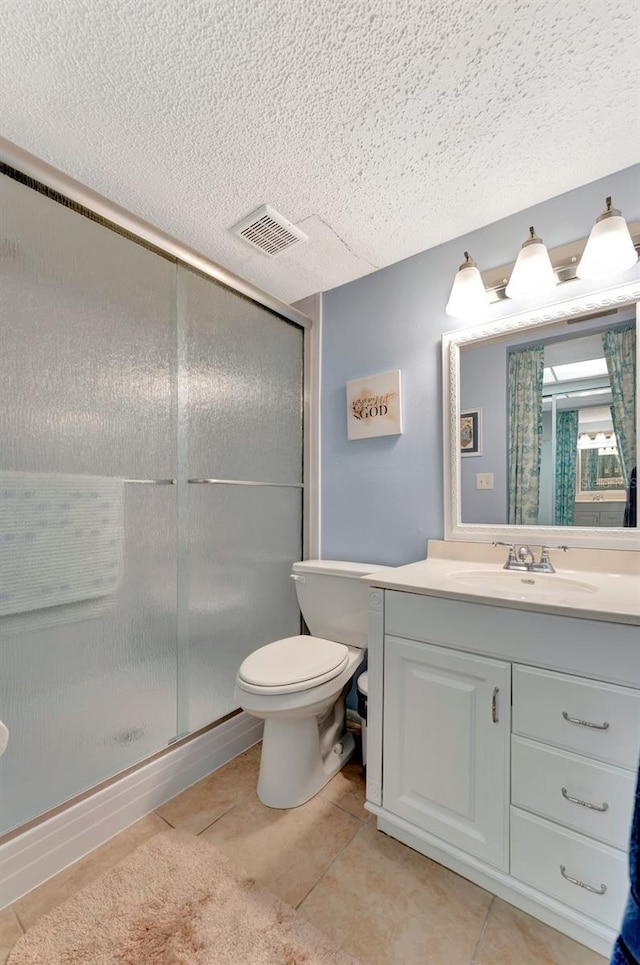 bathroom with visible vents, toilet, vanity, a shower stall, and tile patterned floors