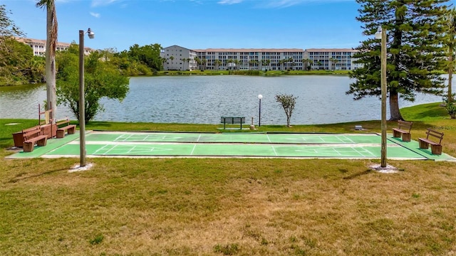 view of community featuring a water view, a yard, and shuffleboard